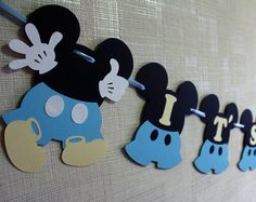 mickey mouse birthday banner with blue and black ones on it, hanging from the wall