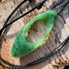 "On offer is a hand-carved organic ribbon freeform carving. Carved from a vibrant chromium green Indonesian nephrite jade peppered with iron inclusions and finished with a black six cord/three plait hand-braided cord. Polished to a matte finish. The \"up to\" dimensions of the carving are 65mm x 26mm x 10mm with a maximum cord length of 25 inches. The pendant and cording weighs 18 grams or 0.63 ounces total. This original design is a play on the visual aesthetic of both the möbius and infinity ribbon designs commonly seen in contemporary jade carving. With two folds and the illusion of a third thoughtfully scooped into the lower interior of the pendant I believe I have created a visually powerful piece with the appearance of an interior and an exterior. Symmetrically carved to further the Unique Green Carved Necklace, Green Oval Carved Necklace, Unique Green Oval Necklaces, Nephrite Jade, Ribbon Design, Jade Carving, Real Stone, Natural Jade, Vibrant Green