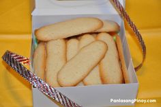 a box filled with cookies sitting on top of a yellow table cloth covered tablecloth