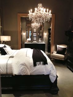 a bedroom with a chandelier hanging from the ceiling and a bed in front of it