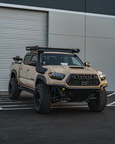 a tan toyota truck parked in front of a building