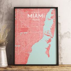 a framed map of miami, florida with the word miami in white and red on it