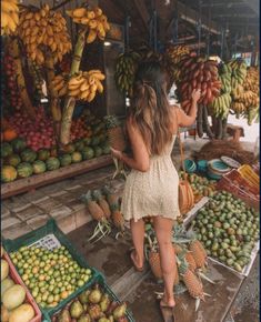 a woman standing in front of a fruit stand