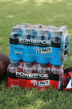 several bottles of powerade are sitting on the grass next to a football and bag