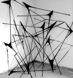 black and white photograph of an abstract sculpture on the floor in front of a wall