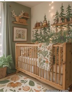 a baby's room decorated with deer and pine tree themed wallpaper, including the crib