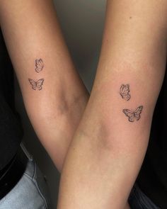 two people holding hands with tattoos on their arms and one has a butterfly tattoo on the arm