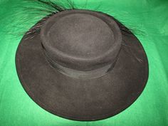 "Mr John black wool fedora style hat with 3 1/2\" wide banded brim, with flurry 5 to 6\" black feathered/ribbon bow band on one side. Possible 1950's era, with circumference of inside crown is 21\". Band is circled with wire band, so it can be shaped for your style. Hat is in very good condition. I believe the feathers are Ostrich. PRICE IS $99.00SALE FINAL/AS IS/NO RETURNS." Winter Feathered Brimmed Felt Hat, Winter Felt Hat With Wide Brim And Feathers, Kentucky Derby Brimmed Felt Hat With Feather Trim, Black Fur Felt Hats For Party, Kentucky Derby Felt Hat With Feather Trim, Formal Brimmed Hat With Feathers, Fitted Wide Brim Hat With Feather Trim, Wide Brim Hat With Feather Trim, Formal Hat With Feather Trim