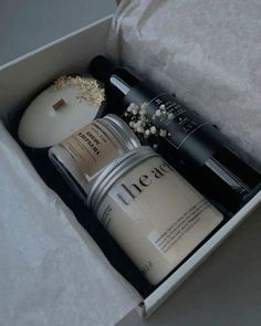 an open box containing two bottles of body lotion and a container with the contents in it