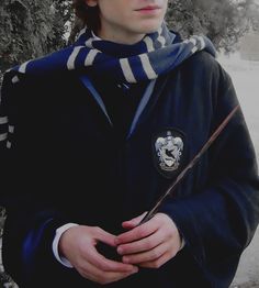 a young man is holding a wand in his hands