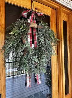 a wreath hanging on the front door of a house