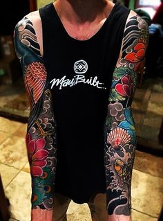 a man with many tattoos on his arms and arm is standing in front of a mirror