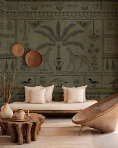 a living room filled with lots of furniture and wallpaper covered in animal designs on the walls