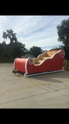 a red and white couch sitting in the middle of a parking lot