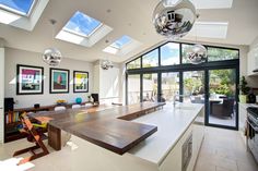 a kitchen with an island and skylights in the ceiling is very large, but it has plenty of windows to let in natural light