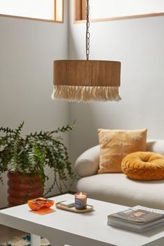 a living room filled with furniture and a white coffee table topped with a candle next to a potted plant