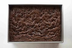 a pan filled with brownies sitting on top of a counter next to a white wall