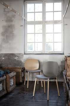 two chairs sitting next to each other in front of a window with no curtains on it