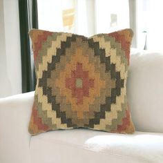 a white couch with a decorative pillow on it