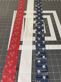 an american flag made out of strips of fabric sitting on top of a cutting board