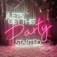 a neon sign that says let's get this party started next to some decorations