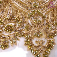 a close up view of an elaborate gold beaded dress