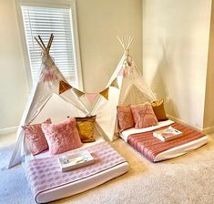 two teepee tents sitting next to each other on top of a carpeted floor