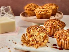 some muffins are on a plate and next to a glass of milk