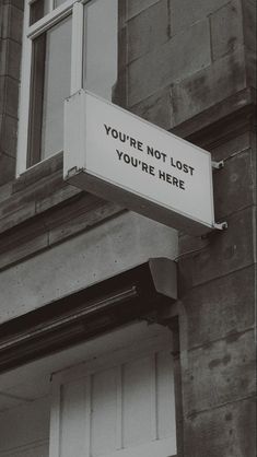 a sign on the side of a building that says, you're not lost you're here