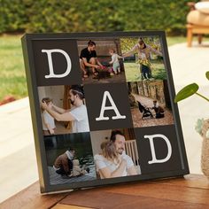 a photo frame with the words dad on it next to a potted plant and vase