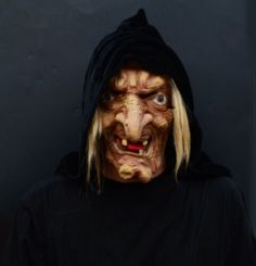 a man with long blonde hair wearing a black hoodie and face painted like a demon