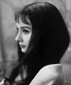 a black and white photo of a woman with long hair looking off to the side