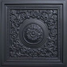 an intricately carved square ceiling tile in black