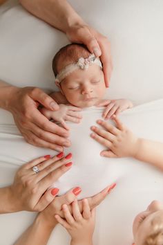 a group of people holding and touching a baby