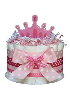 a pink and white polka dot diaper cake with a crown on it's top