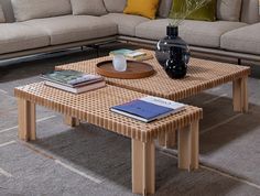 a living room with a couch, coffee table and books on the floor in front of it