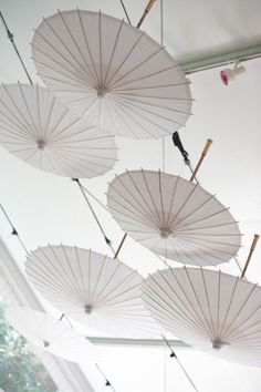 several white umbrellas hanging from the ceiling