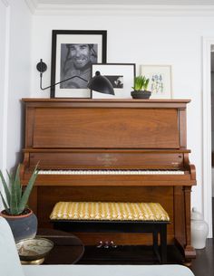 a living room with a piano and pictures on the wall