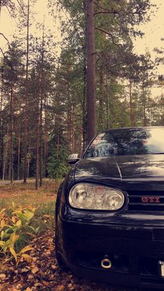 a black sports car parked in the woods