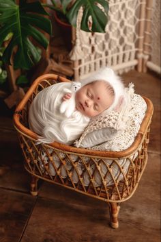 a newborn baby is sleeping in a wicker basket