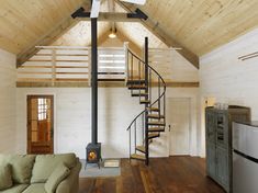 an image of a living room with stairs in the ceiling and wood flooring on the walls