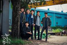 a group of young men standing next to each other in front of a blue building