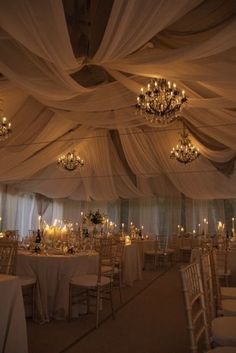 an image of a wedding venue with chandeliers and white drapes on the ceiling