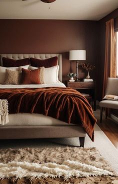 a bedroom with brown walls and white bedding, rugs on the wooden floor