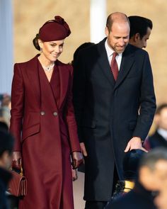 two people in suits and hats walking next to each other