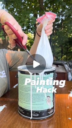 a person is painting a bucket with white paint