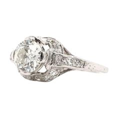 This antique piece was handcrafted sometime during the Edwardian design period (1900-1920). The incredible platinum setting features a center diamond measuring approximately 0.90 carats. The center diamond is an Old European cut. The diamond grades approximately J in color and SI1 in clarity. The platinum setting features intricate open work filigree accented beautifully by 18 sparkling diamond accents. The solitaire style features antique hand engravings and minimal milgrain accents. This plati Edwardian Design, Sparkling Diamond, Filigree Ring, Jewelry Rings Engagement, Sparkle Diamonds, Hand Engraving, Ring Verlobung, Platinum, Jewelry Rings