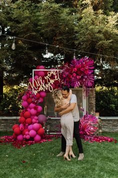 a man and woman embracing in front of a sign