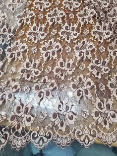 an old lace with brown and white designs on it