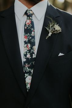 a man in a suit with a flower on his lapel and a boutonniere